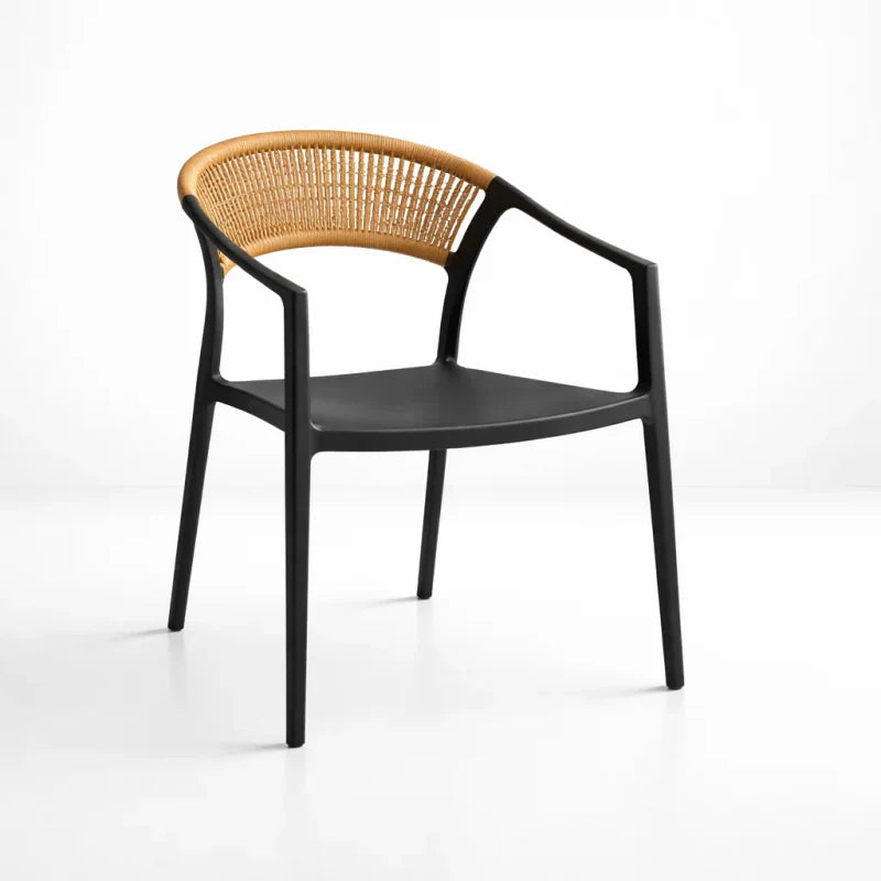 Silla Verona de ratán natural con respaldo curvo y estructura negra, diseño moderno con apoyabrazos ergonómicos. Ideal para comedor, living, terraza techada, cafeterías y restaurantes. Silla elegante, resistente y cómoda para espacios nórdicos, boho y contemporáneos.